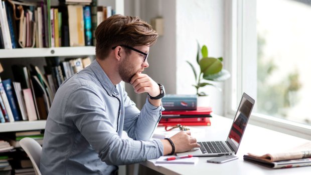 en mand sidder på et kontor med sin bærbare computer