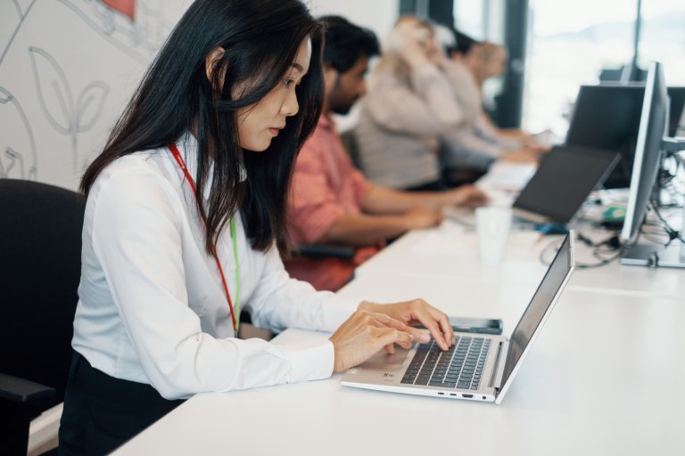 En kvinde sidder foran en computer og skriver på tastaturet