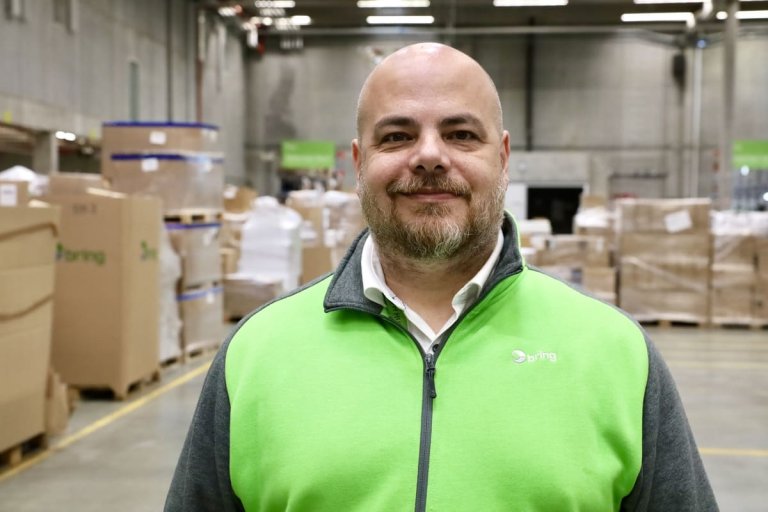 En mand som står på et lager med pakker i baggrunden